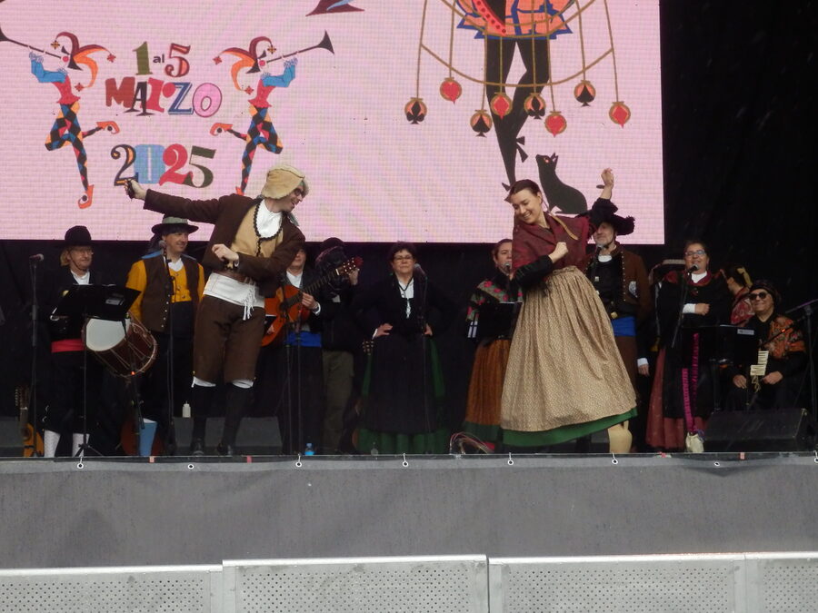 Pareja bailando con traje tradicional sobre un escenario de carnaval