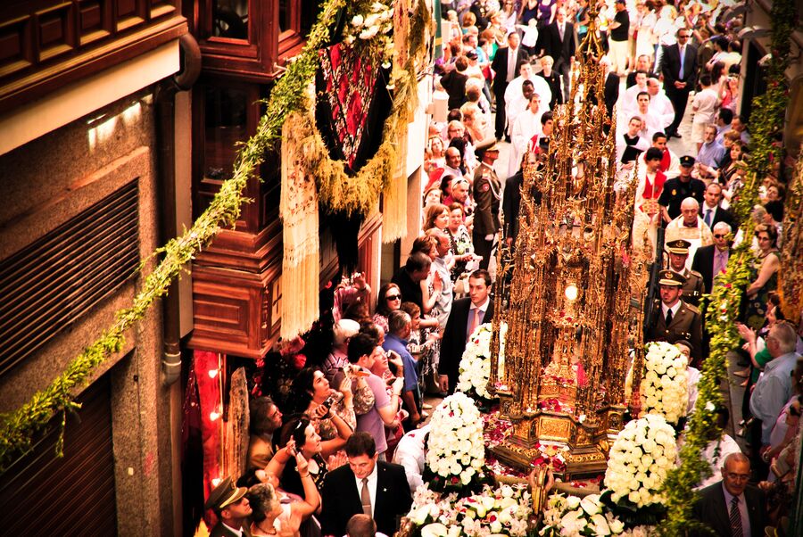 Procesión del Corpus Christi por una calle engalanada de Toledo